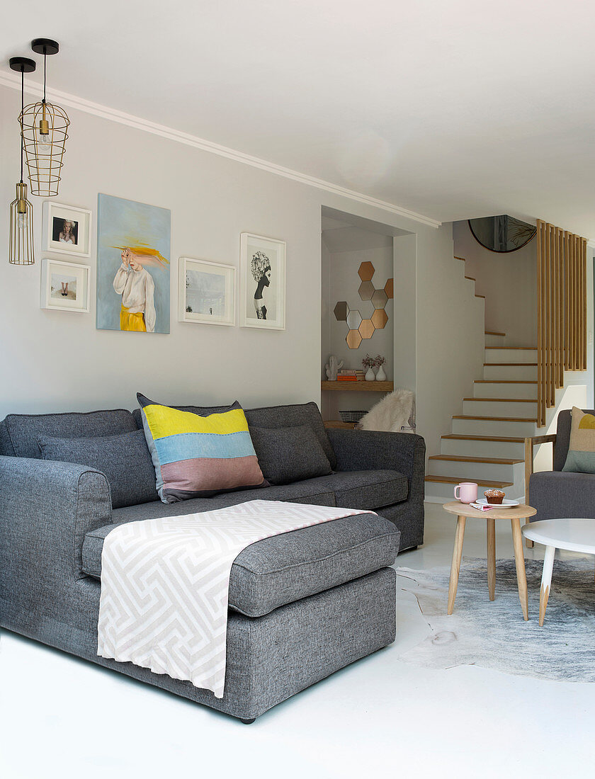Grey sofa in modern living room with foot of staircase in background