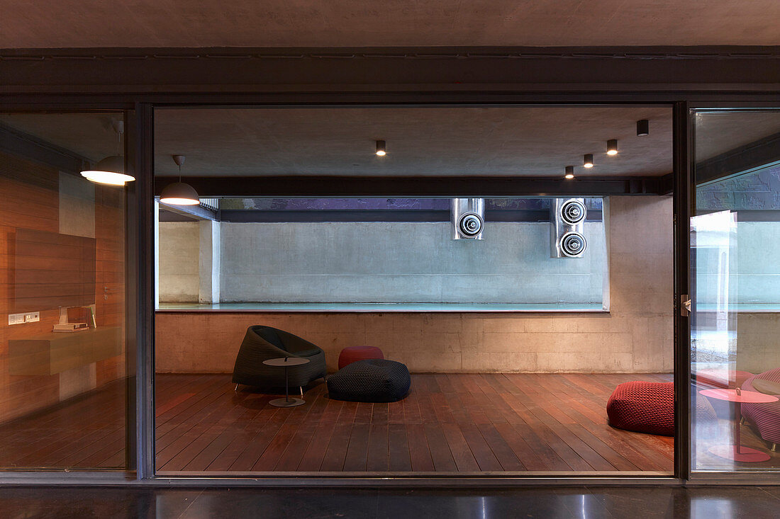 Minimalistischer Wohnraum mit Bodenkissen auf dem Holzboden