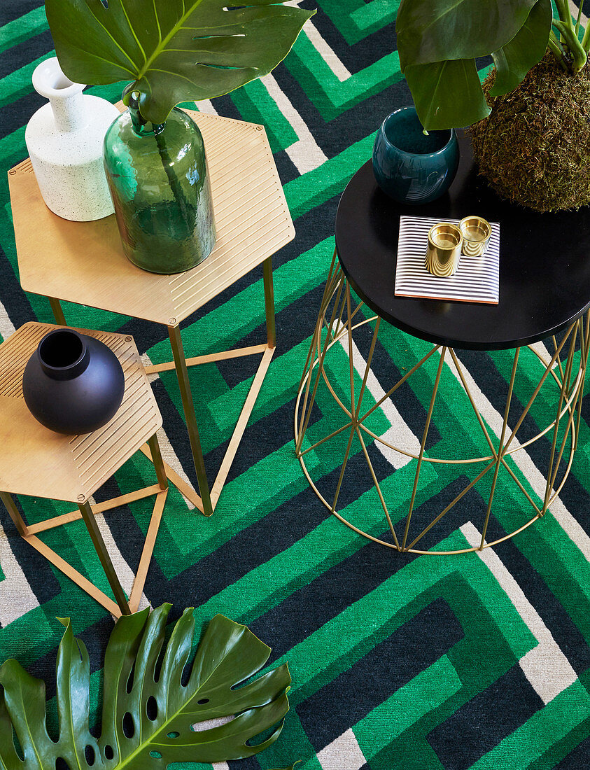 Various side tables on green-patterned rug