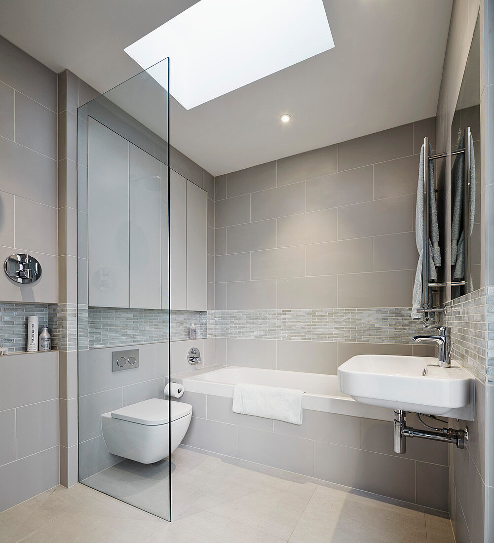 Bathroom in shades of grey with skylight and floor-level shower