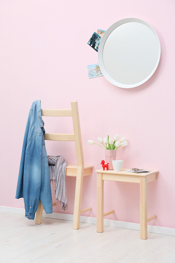 Coat rack and shelf made from halved chair against pink wall