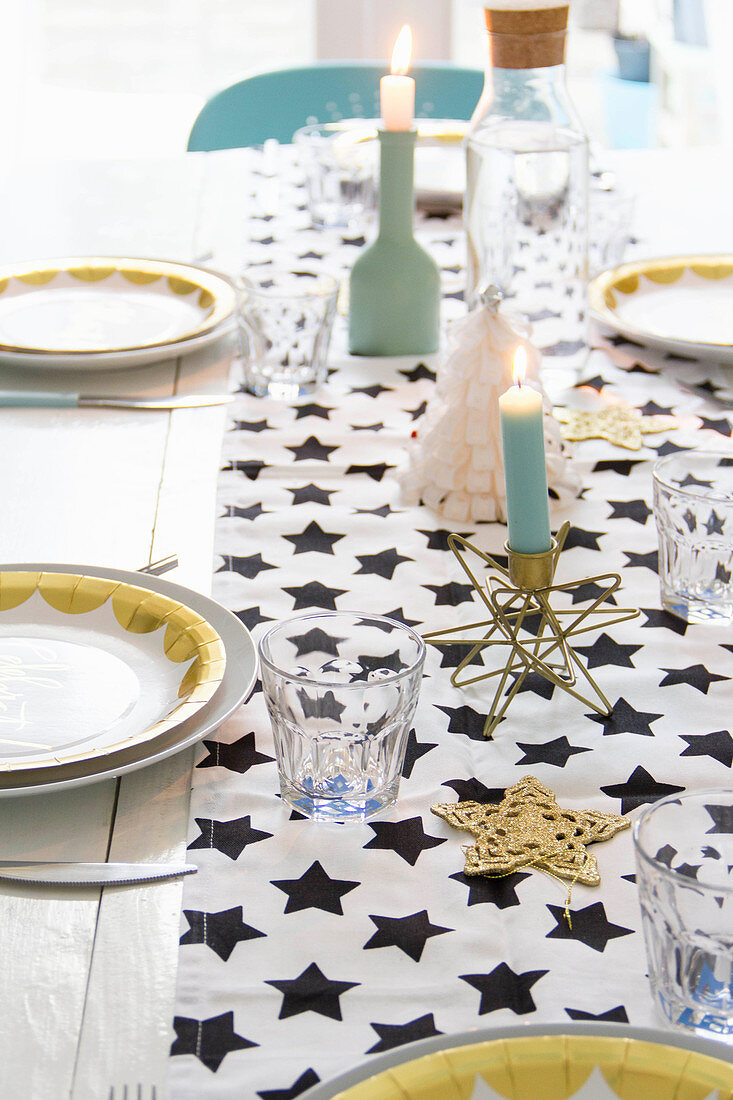 Tischläufer mit Sternenmuster auf weihnachtlich gedecktem Tisch