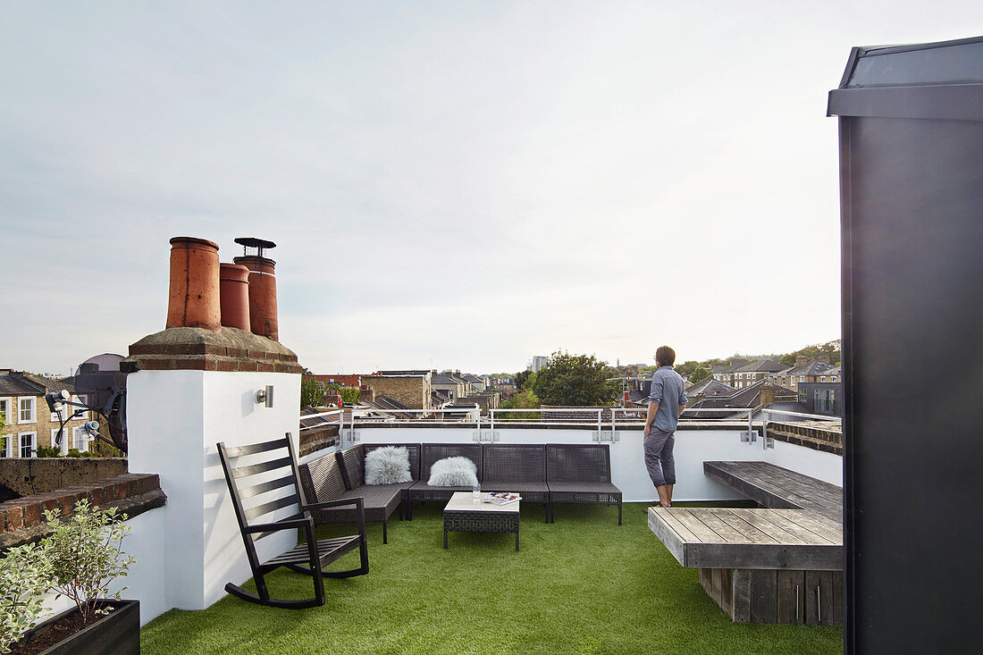 Man standing on roof terrace with city view