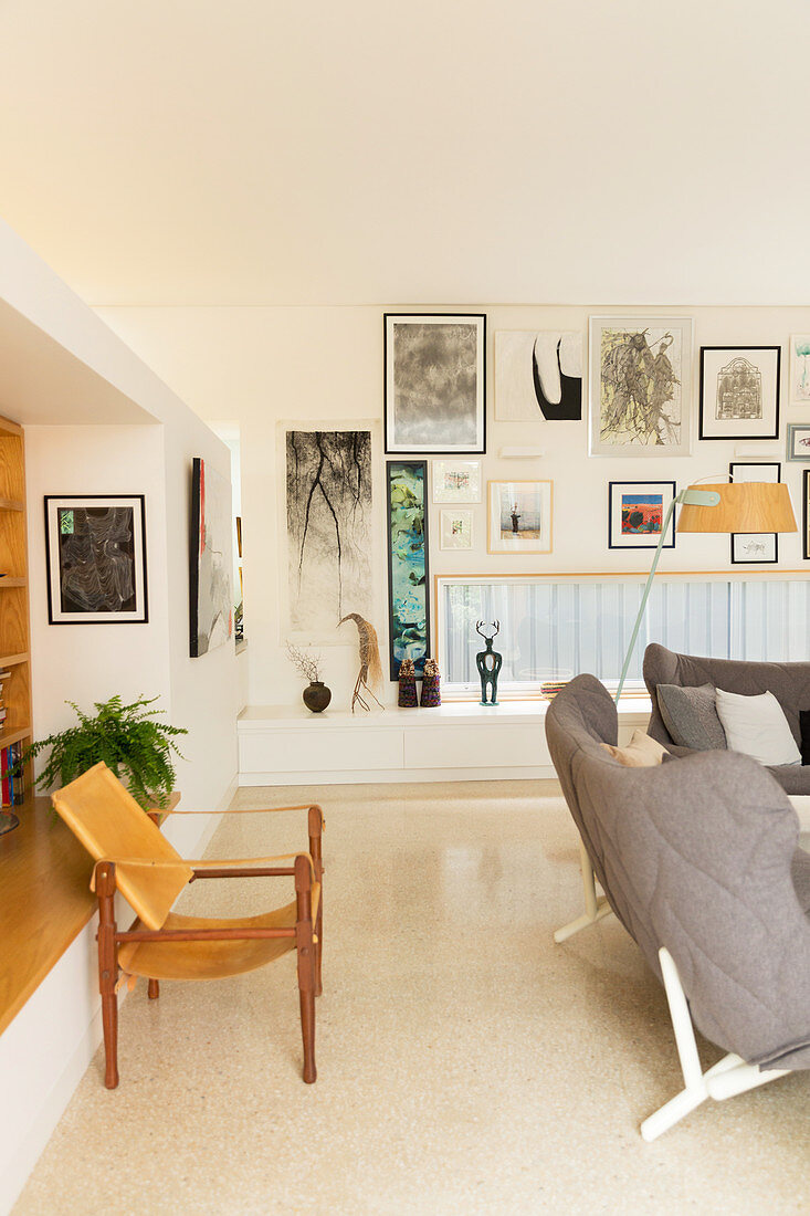 Designerstuhl im Wohnzimmer mit horizontalem Fenster und Bilderwand
