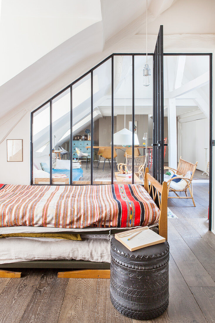 Blick vom Schlafzimmer durch Glas-Stahl-Wand in den Wohnraum