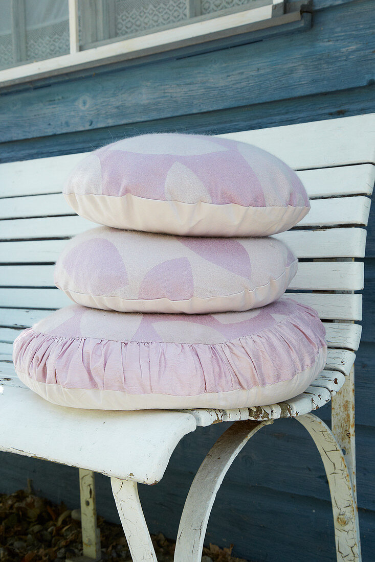 Cushions with hand-sewn covers on wooden bench