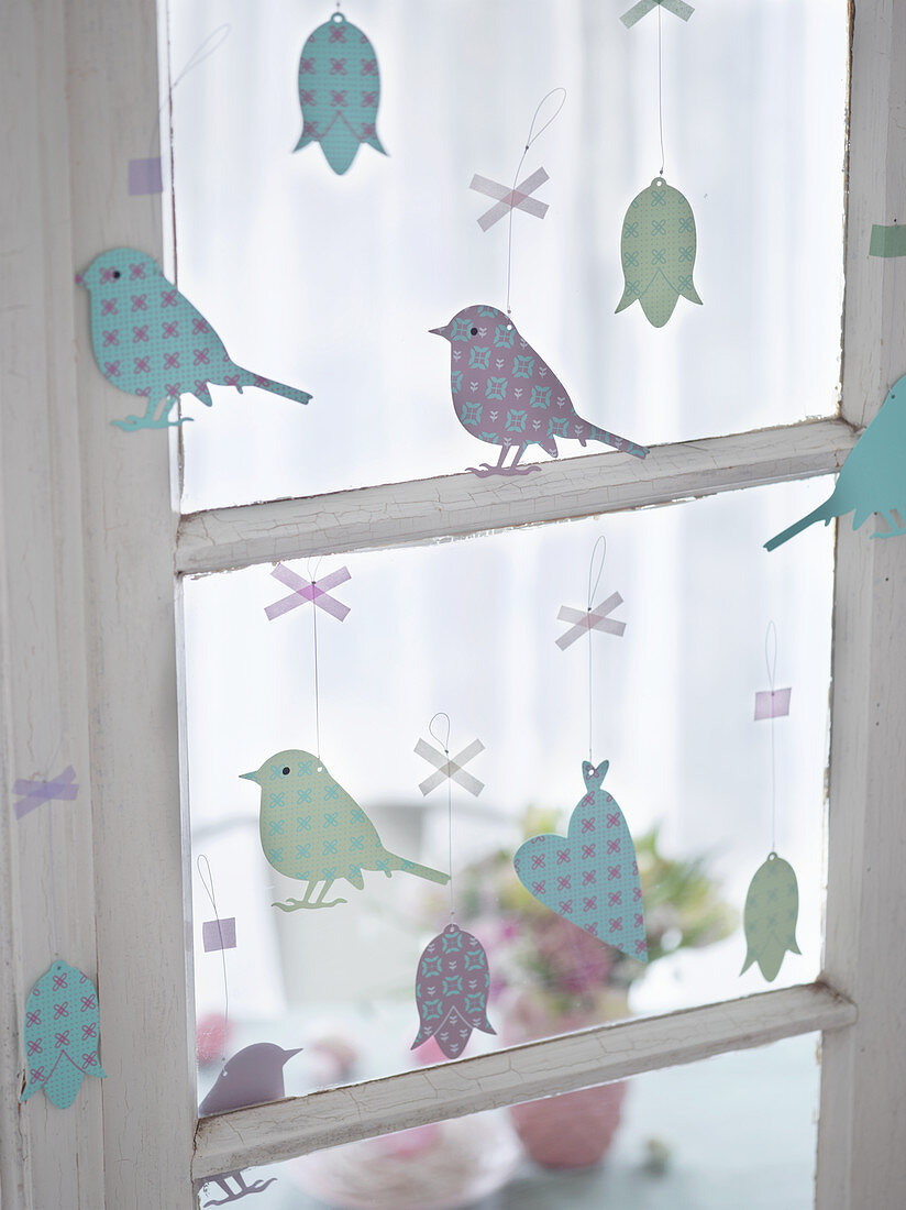 Metallanhänger am Fenster (Vögel, Blumen, Herzen) als Osterdeko