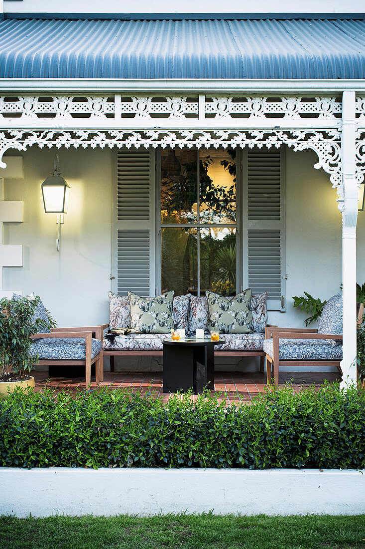 Blick vom Garten auf die Terrasse mit Sitzmöbeln und Markise