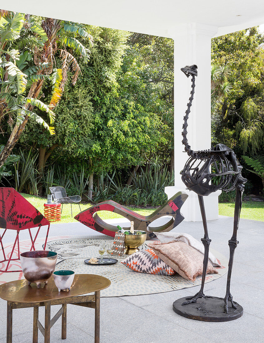 Designer furnishings and bird skeleton in seating area on roofed terrace