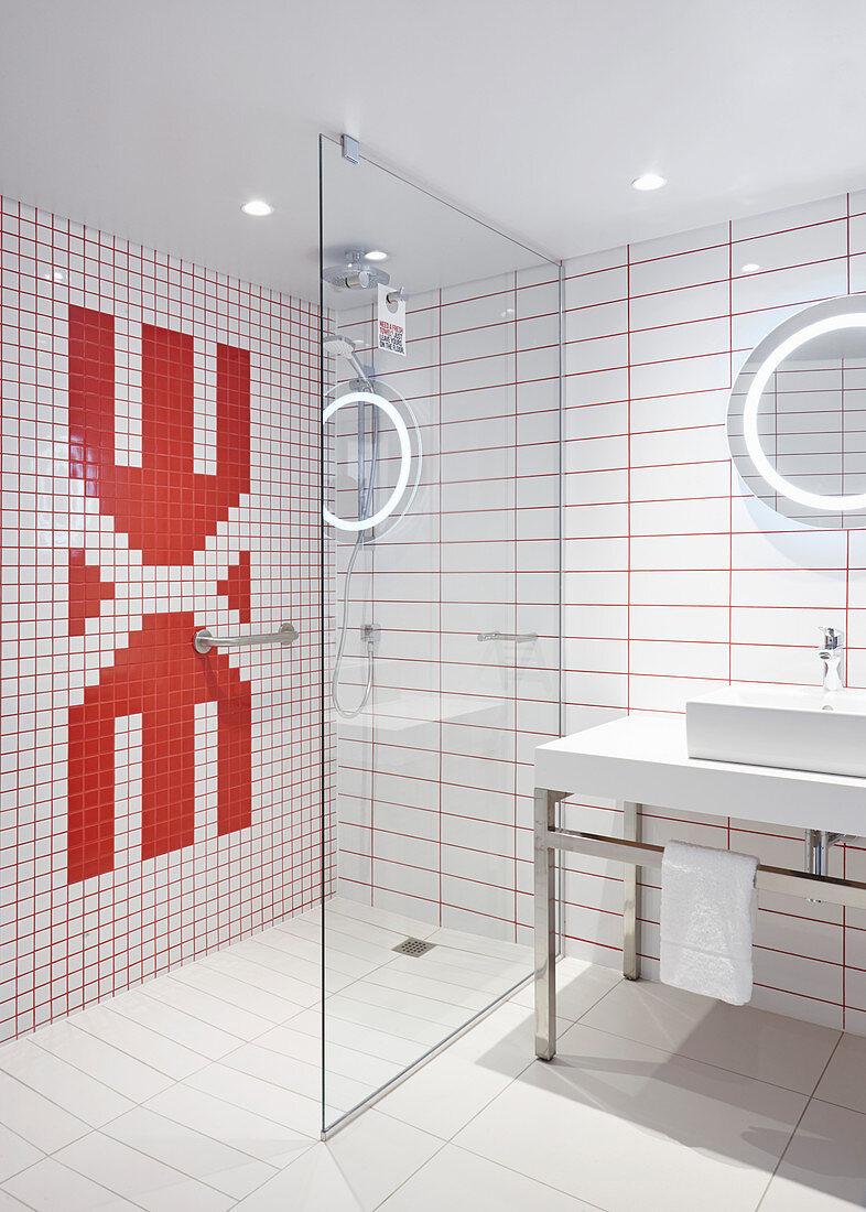 Designerbad mit rot-weißen Wandfliesen und Glastrennwand