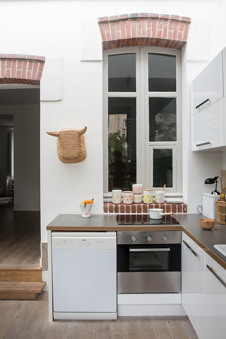 Arched, interior window in white, open-plan kitchen