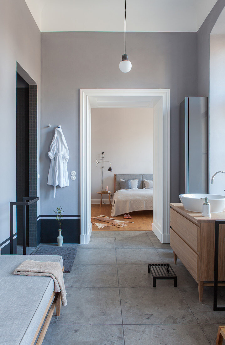 Blick vom modernen Bad in Grau ins Schlafzimmer