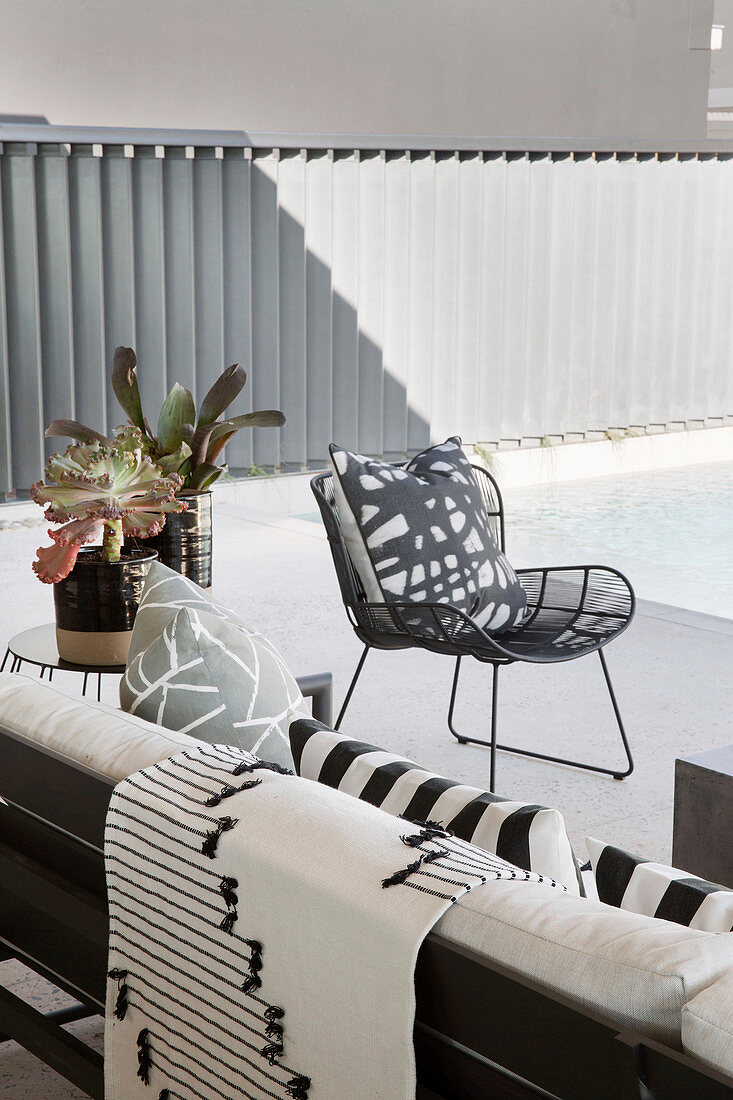Schwarz-weiß gemusterte Textilien auf Sofa und Sessel auf der Terrasse
