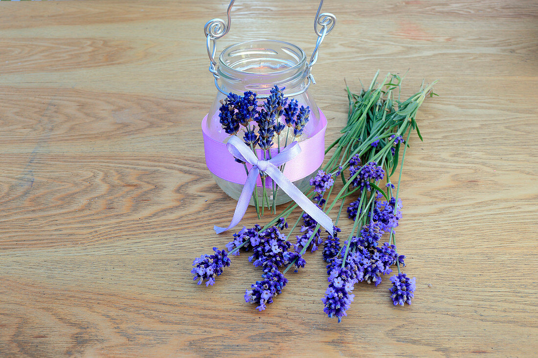 DIY-Windlicht mit duftenden Lavendelblüten und lila Dekoband