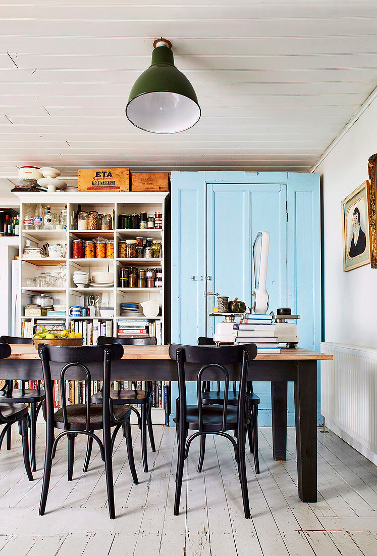 Esstisch mit Stühlen in Küche mit blau lackiertem Schrank und Vintage Regal