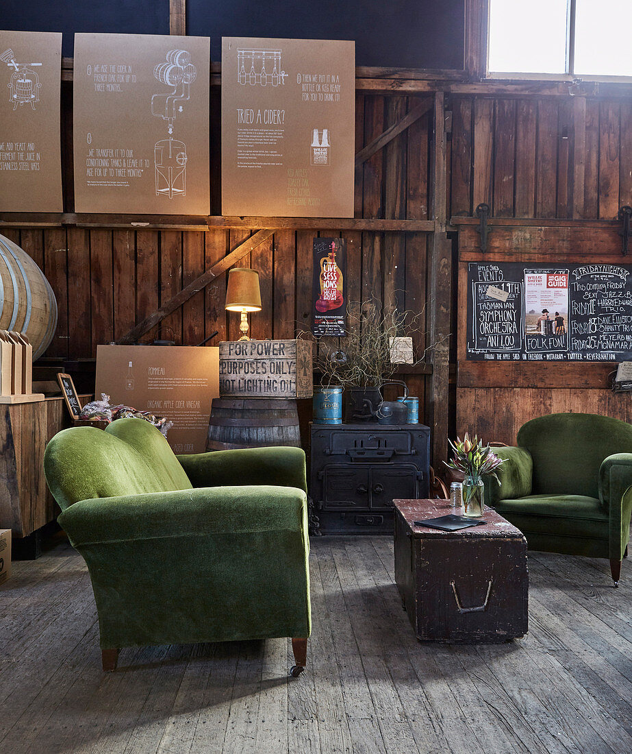 Green upholstered furniture and vintage accessories in lounge with wooden paneling