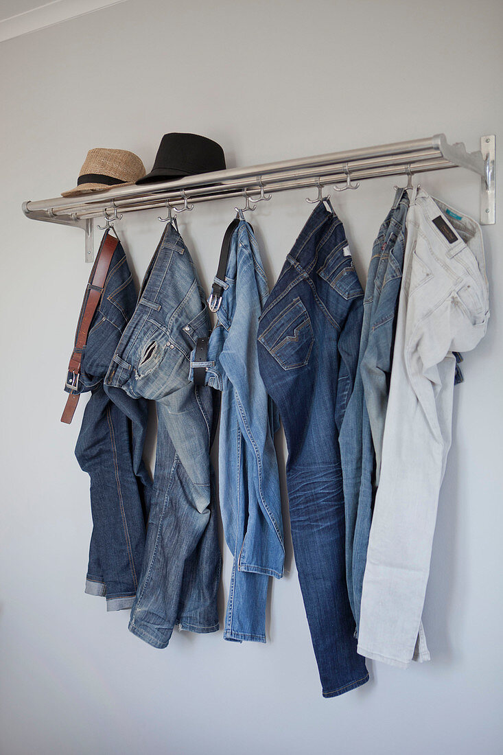 Jeanshosen hängen an einer Garderobe
