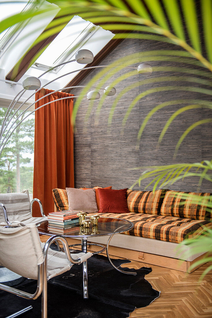 View into retro living room through palm leaf