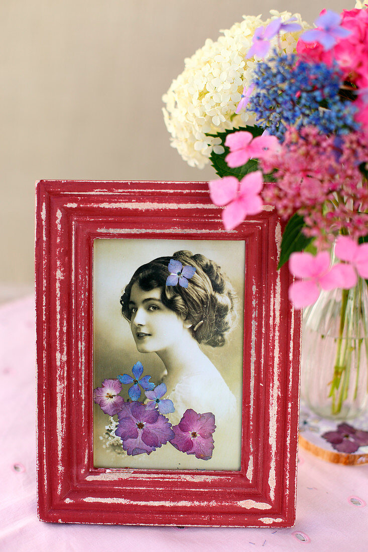 Nostalgische Fotografie im roten Rahmen mit gepressten Blüten