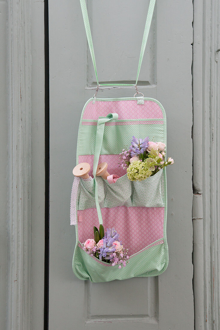 Posies and thread reels in organiser made from mint-green and pink fabric
