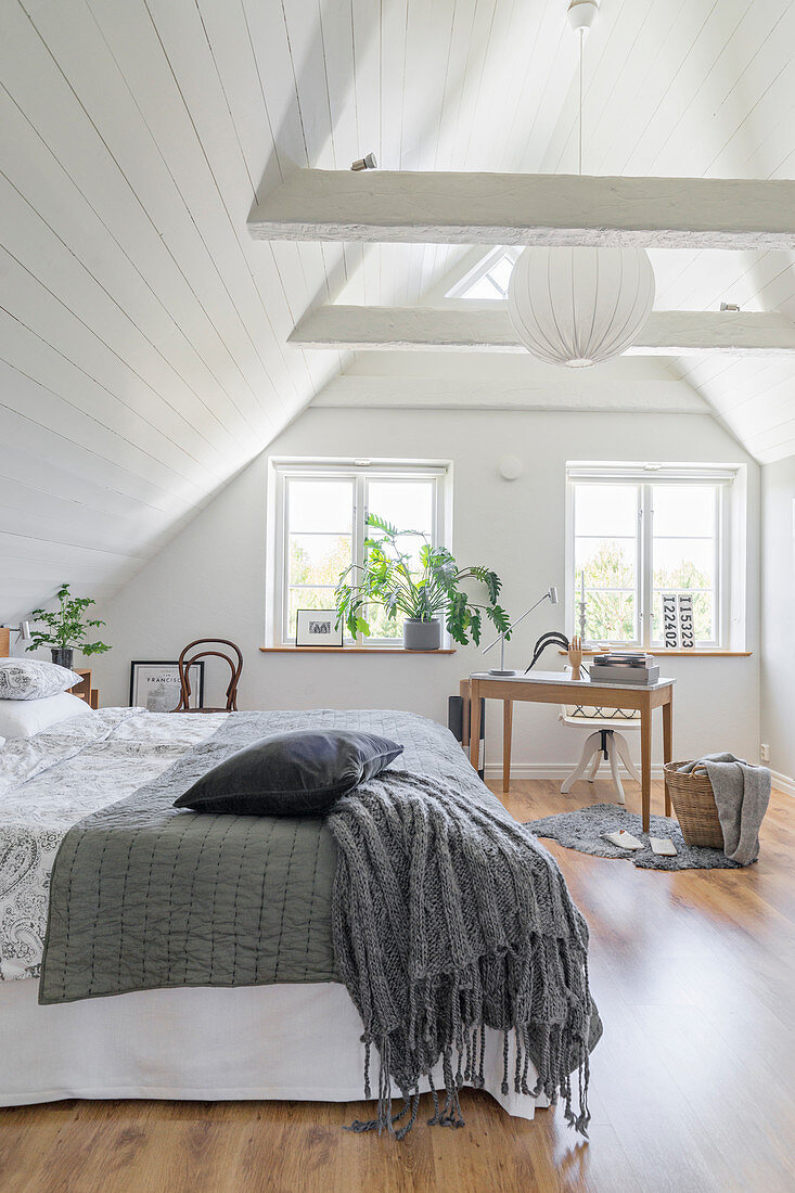 Schlafzimmer mit weißer Holzverkleidung im Dachgeschoss