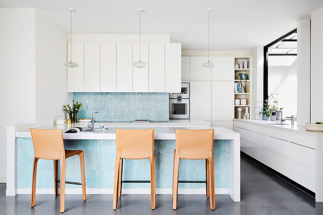 Kitchen counter with turquoise blue mosaic tiles and leather bar stools