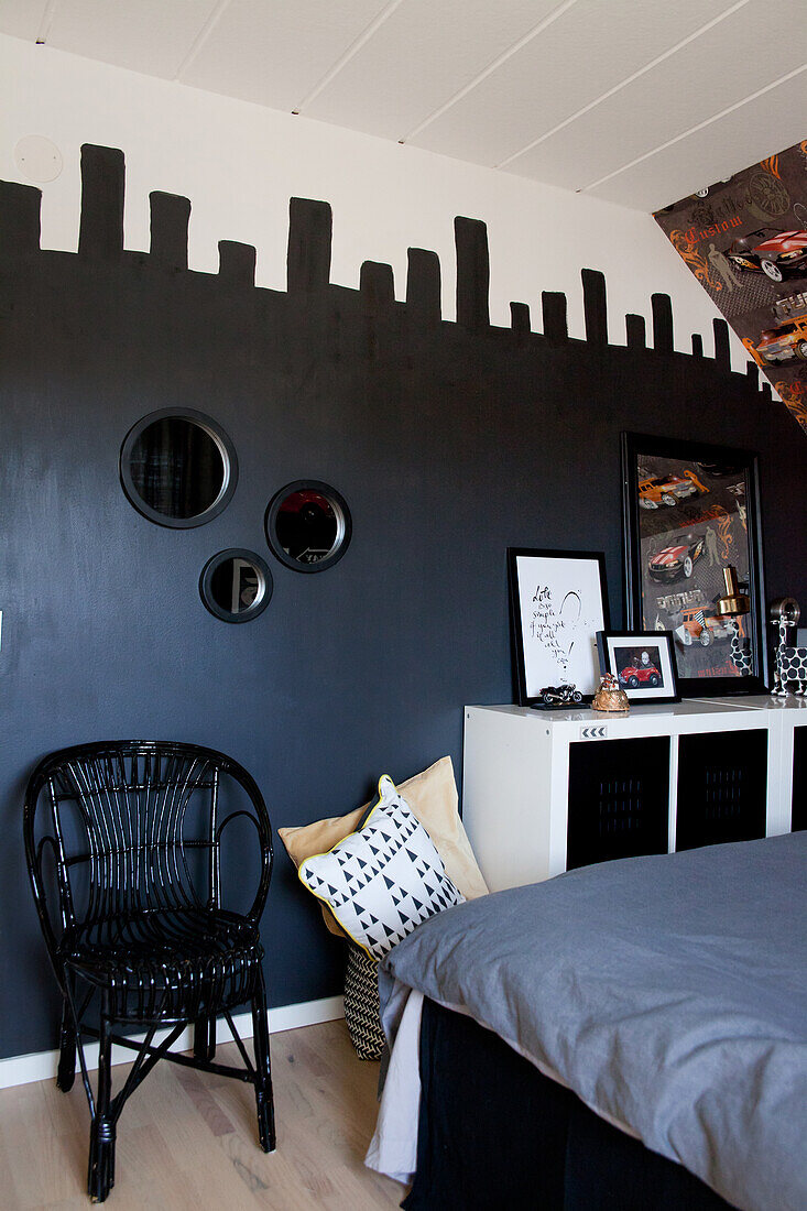 Black chair against black-painted wall in teenager's bedroom