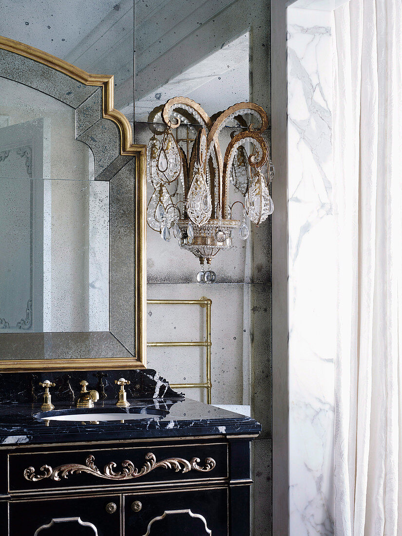 Antiker Waschtisch mit Marmorplatte und Kristallleuchte im Badezimmer in französischem Barockstil