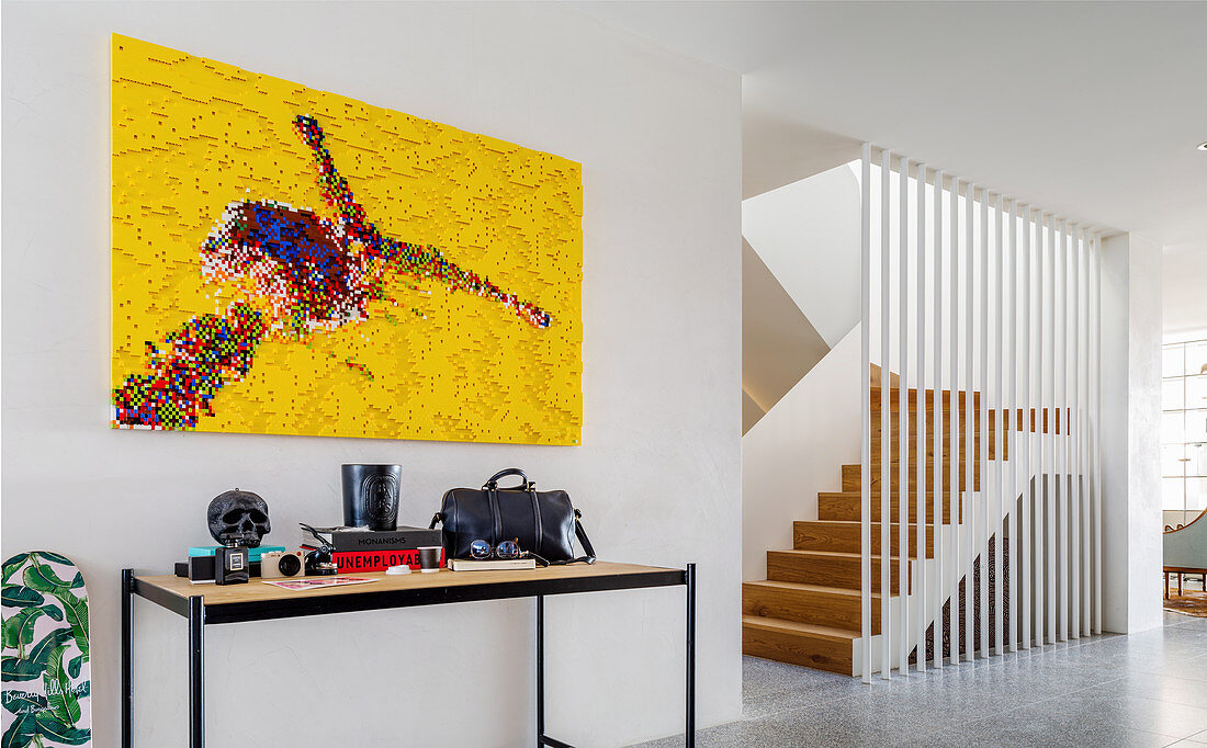 Modern art above console table, staircase in background