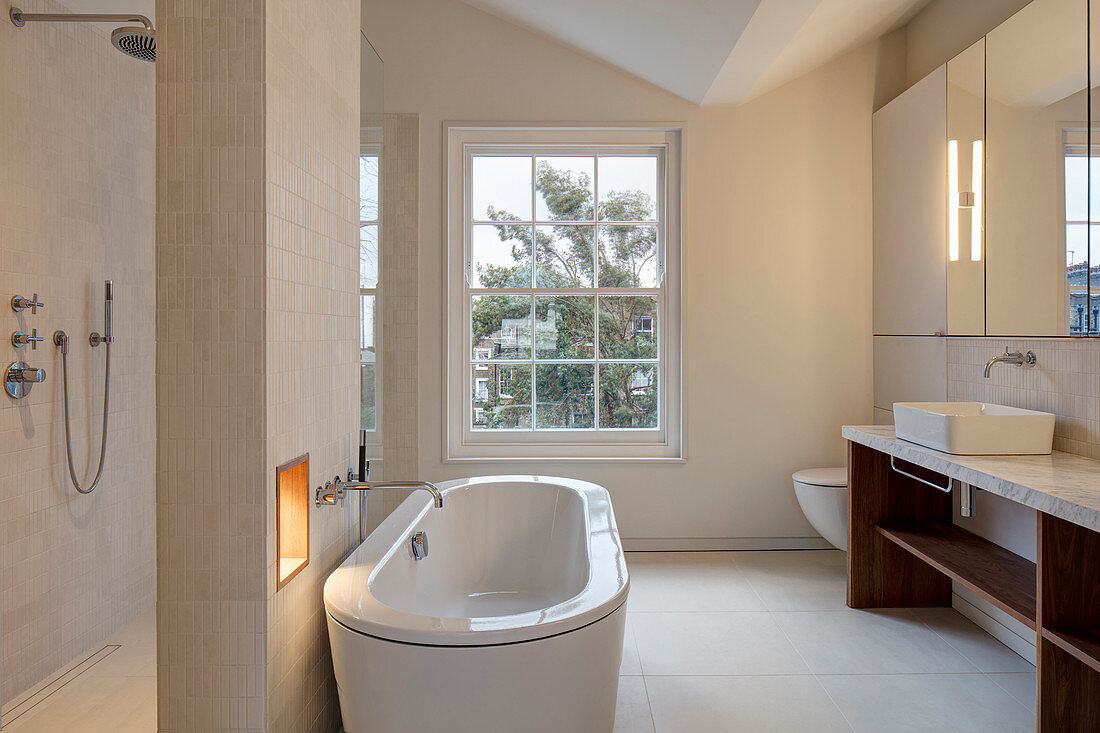 Freistehende Badewanne an Raumteilerwand im modernen Bad