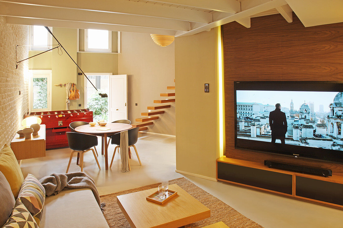 Großer Fernseher im offenen Wohnraum mit Haustür
