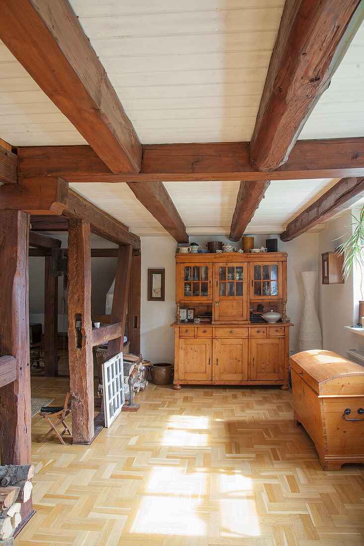 Alte Holztruhe und Anrichte im Raum mit Holzbalkendecke