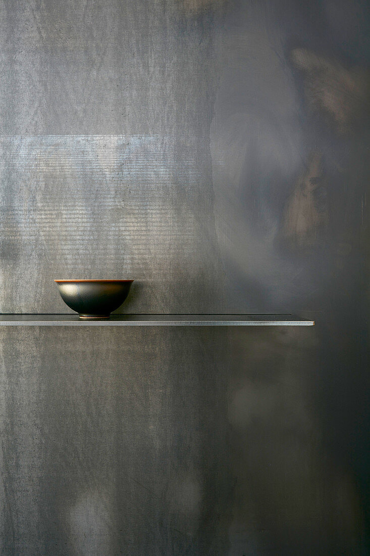 Bowl on simple shelf on black wall