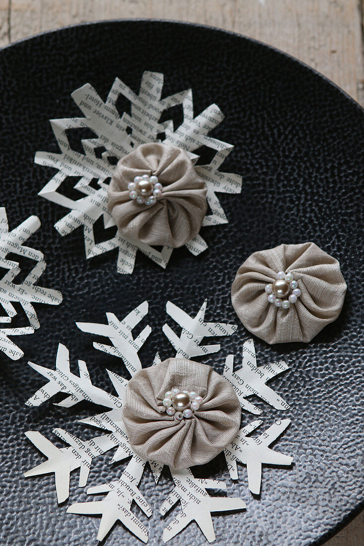 Stoffrosetten mit Perlen und Schneeflocken aus Papier