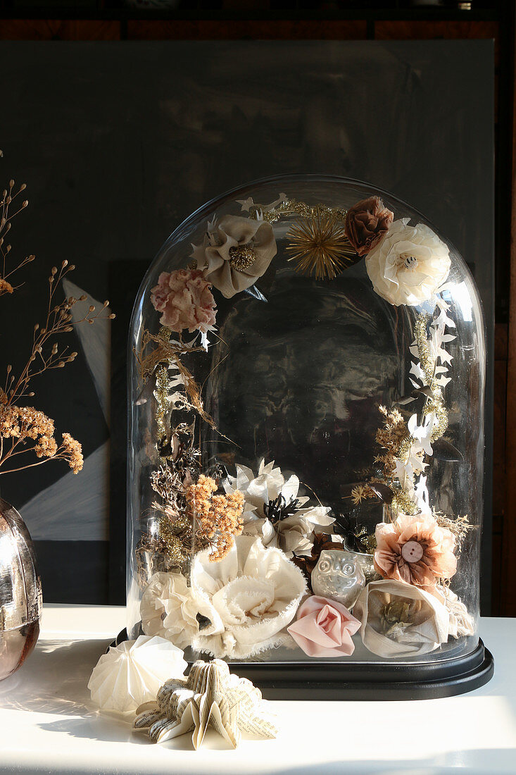 Nostalgische Deko mit filigranem Blumenkranz unter einer Glashaube