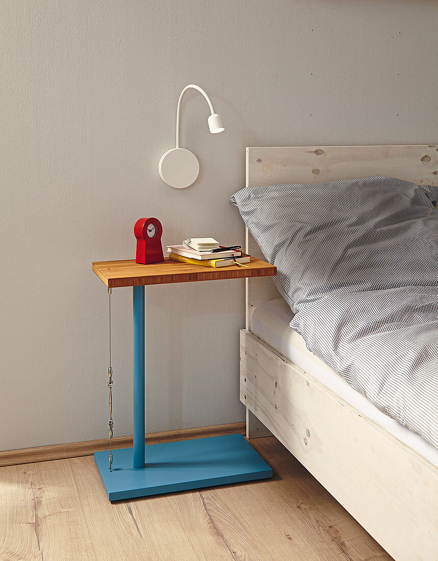 Selbstgebauter blauer Nachttisch mit Bambusplatte und Stahlseil am Bett