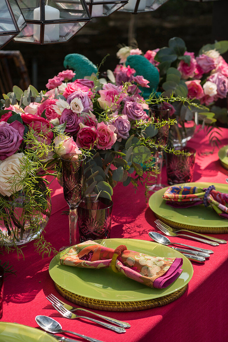 Vases of flowers decorating table set with green plates