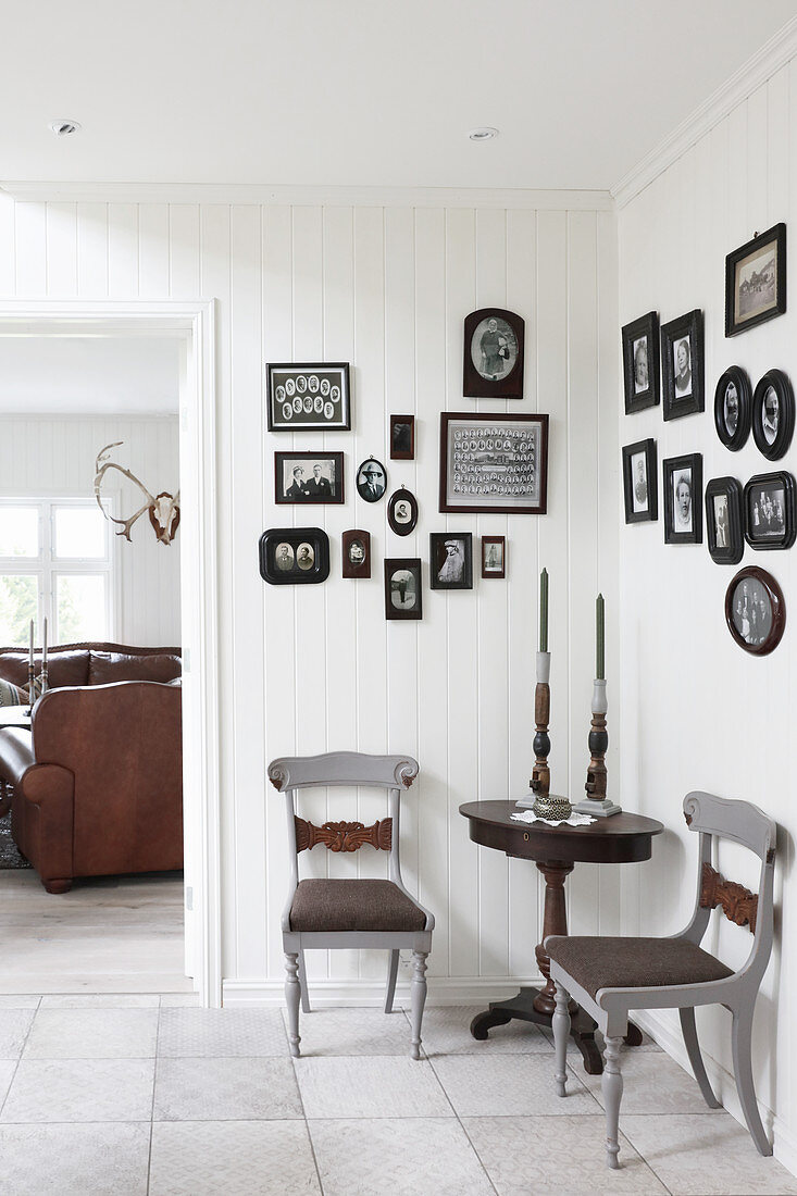 Pictures with black frames on walls of vintage-style seating area