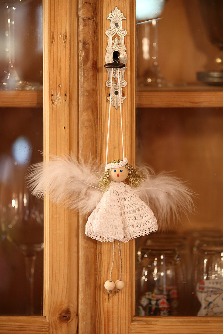 Handcrafted angel decoration with crocheted dress hung from cabinet key