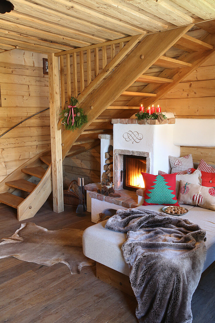 Cosy couch with cushions next to wood-burning stove