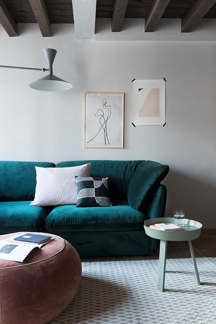 Pouffe and round tray table in front of teal sofa