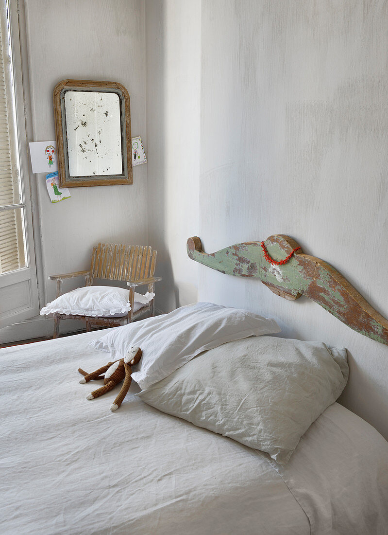Bed headboard with peeling paint in simple bedroom
