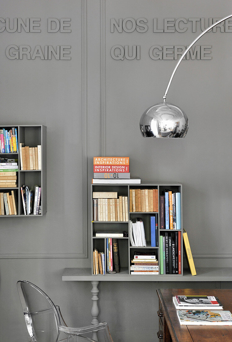 Square book shelves on grey panelled wall with decorative lettering