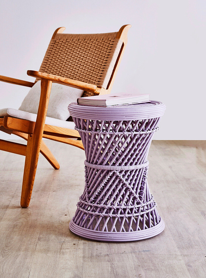 Lilac-colored side table in front of armchair