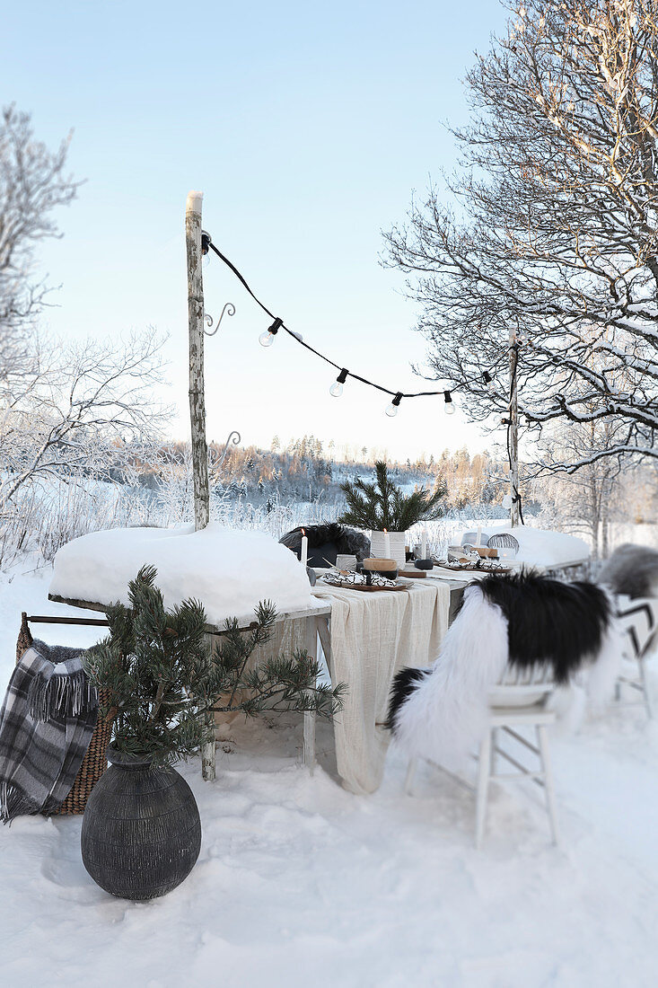 Gedeckter Tisch mit Weihnachtsdekoration im Schnee