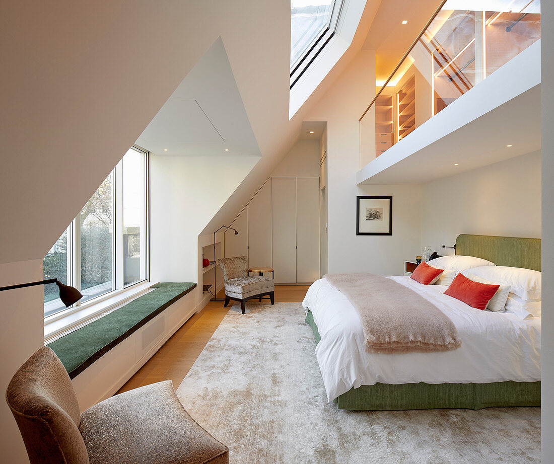 Elegantes Schlafzimmer in doppelter Raumhöhe, Galerie mit Glasbalustrade über Doppelbett