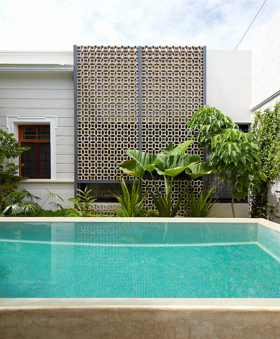 Pool im exotischen Innenhof mit halboffener Mauer mit Ornament