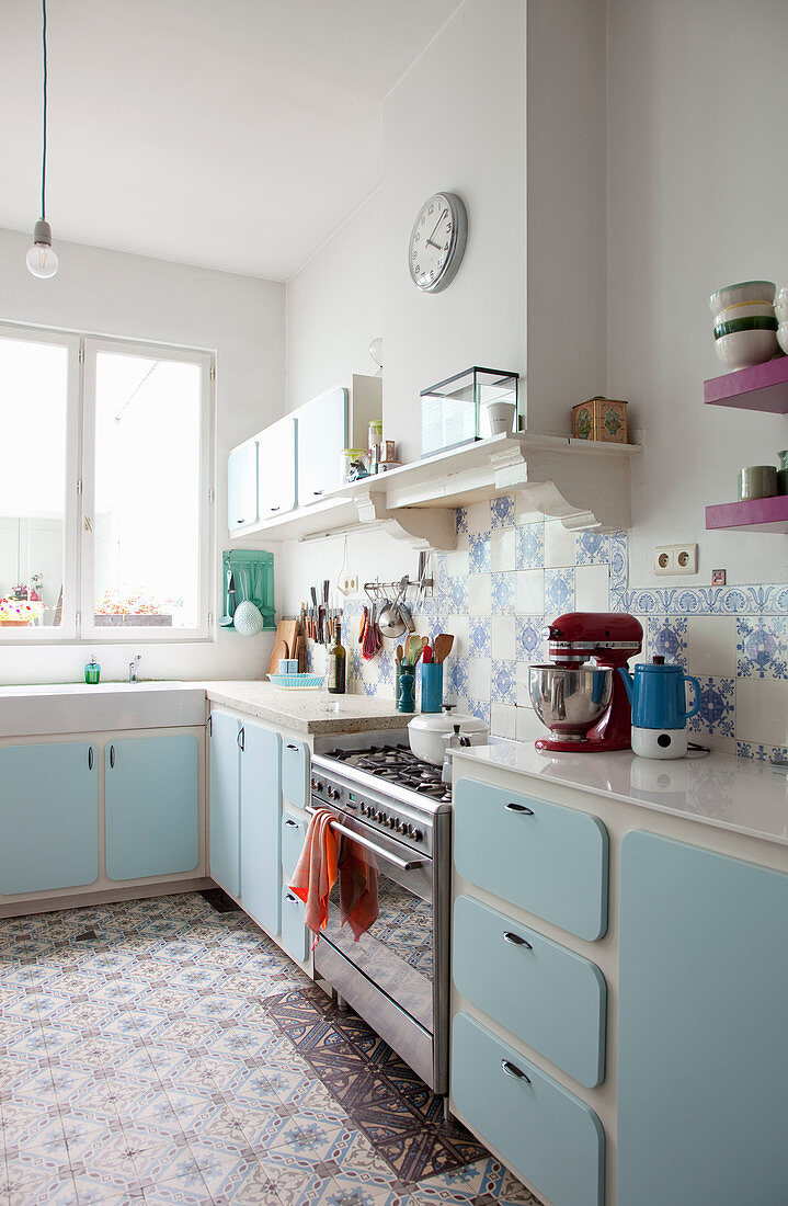 Küche mit hellblauen Schrankfronten und gemusterten Fliesen