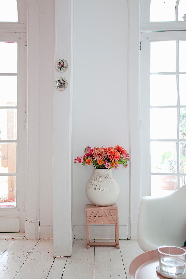 Herbstlicher Blumenstrauß in Vase vor weißer Wand