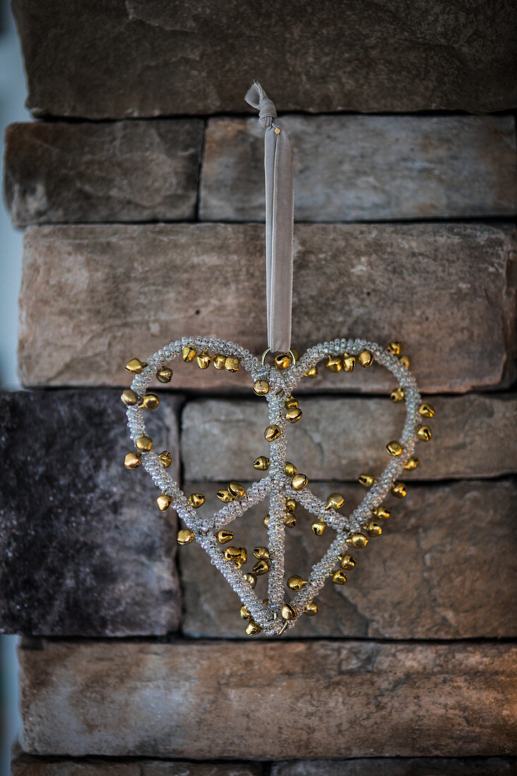 Heart-shaped Christmas decoration covered in tiny golden jingle bells